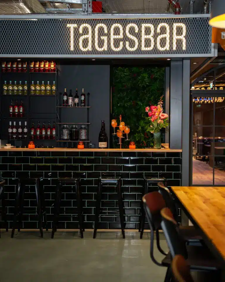 Moderne Tagesbar in der Markthalle im Königshof Essen mit stilvollem schwarzen Design und gemütlicher Atmosphäre.