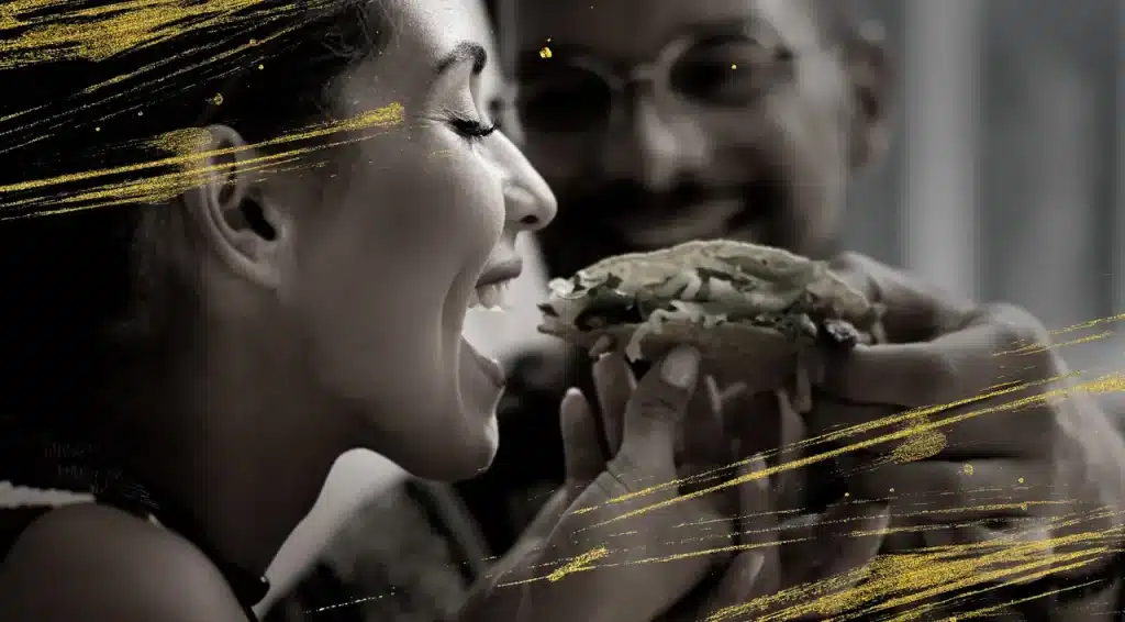 Frau isst einen Burger und lächelt, Szene aus der Markthalle im Königshof Essen.